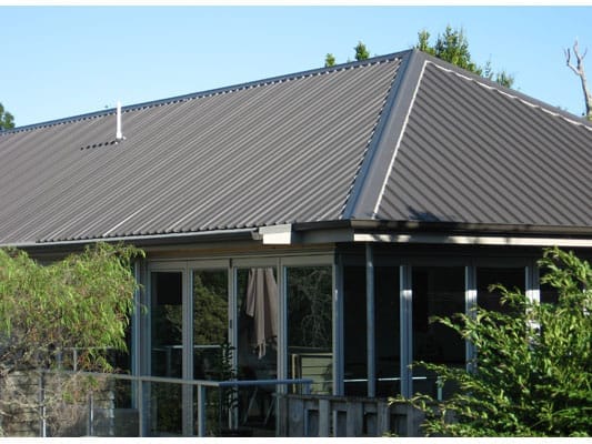 Modern home with dark metal roof panels installed by Dr Roof NZ, showcasing professional re-roofing craftsmanship.