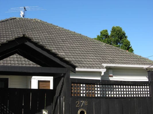 Residential house with concrete tile roof maintained by Dr Roof NZ, showing roof cleaning and restoration work.